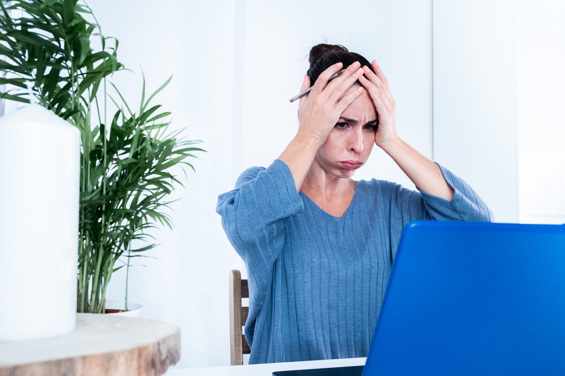 Mujer adulta joven molesta mirando la pantalla del portátil estresada, preocupada y cansada en la sala de estar. Mujer irritada que trabaja de forma remota en casa por un mal trabajo de dispositivos, baja conexión a Internet. Freelance en ciberespacio y r